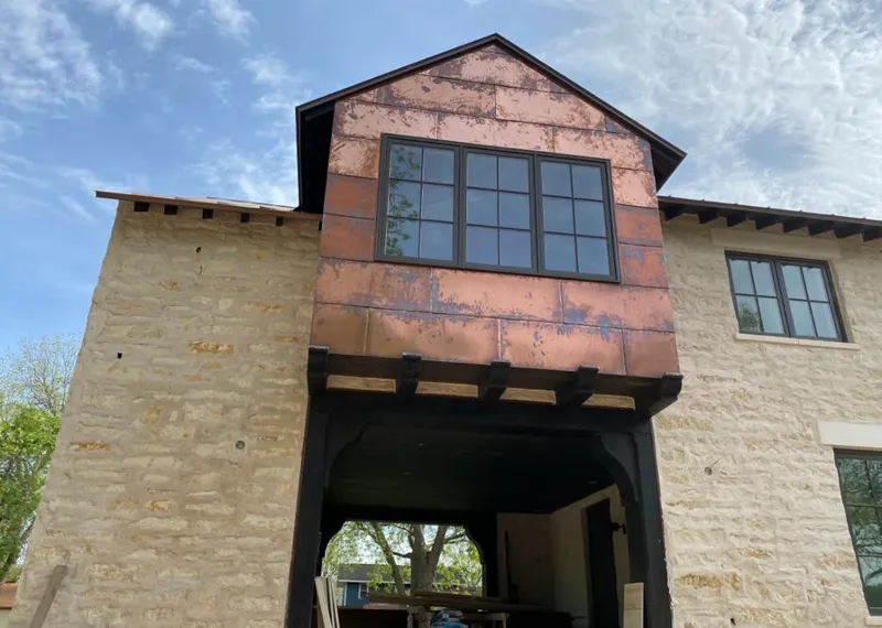 Copper metal panel facade on a stone building for Roof Repair in Macomb